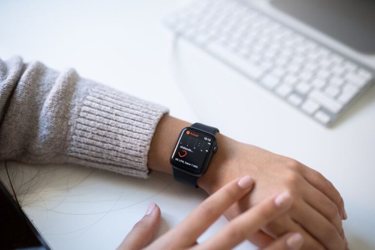 Pergelangan tangan memakai smartwatch di sebelah papan kekunci