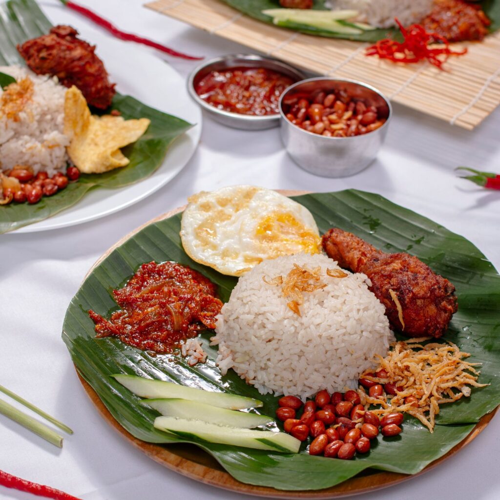 Nasi lemak atas daun pisang dengan telur, kacang dan sambal